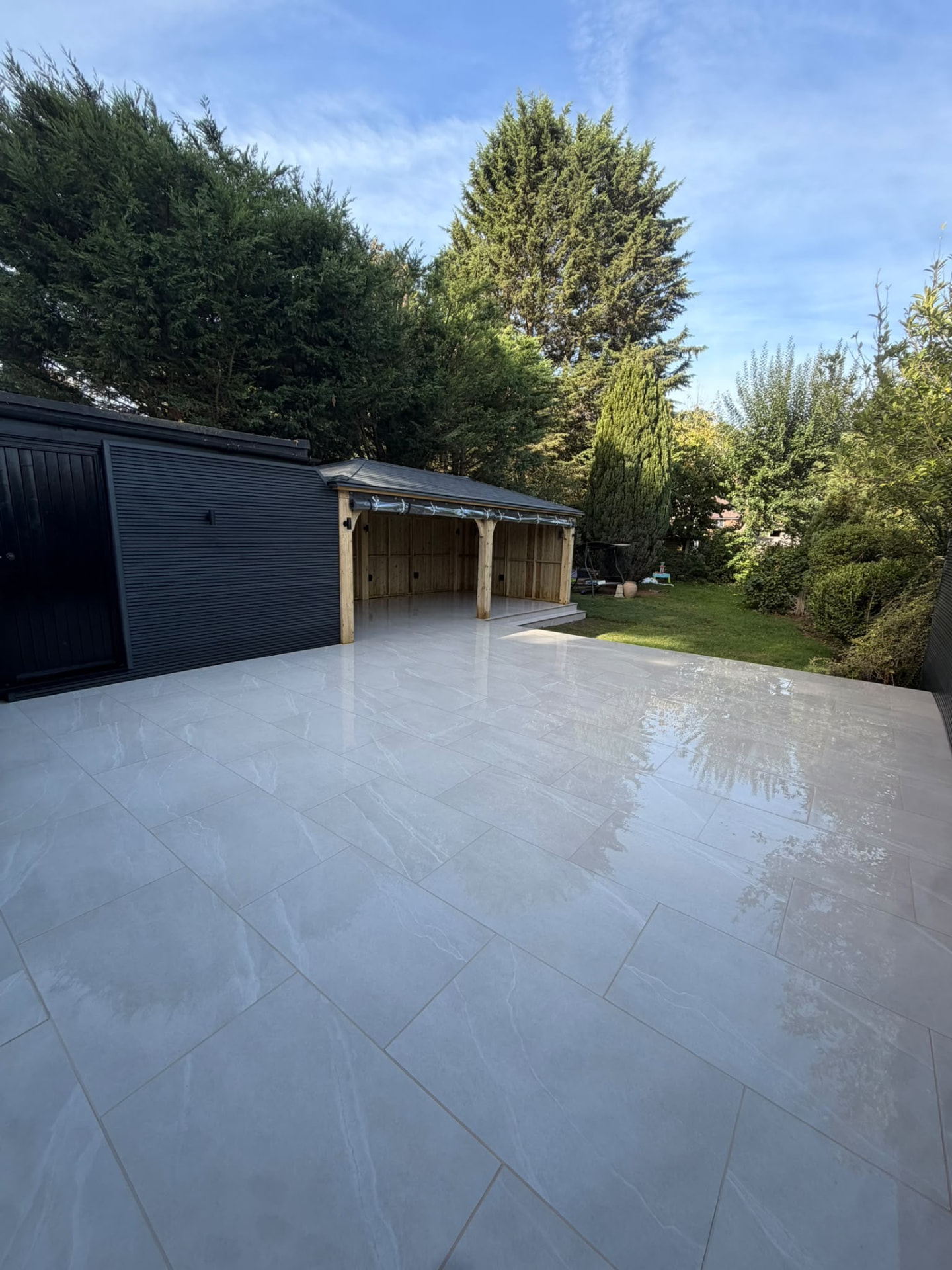 Porcelain patio and covered garden room with lawn beyond
