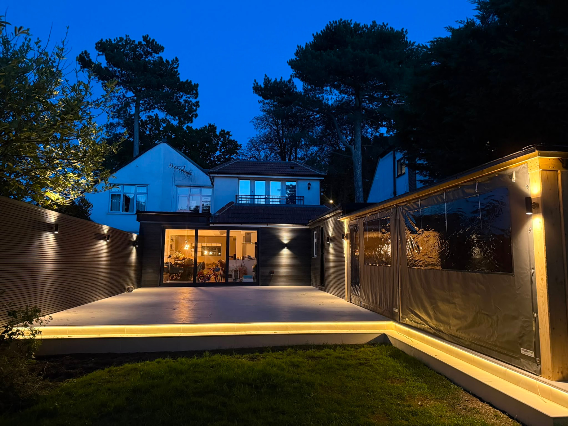 The finished patio and cladding lit up at dusk with LED step lighting